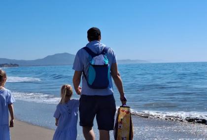 Nuutti Tervo walking on a beach with his two young children. 