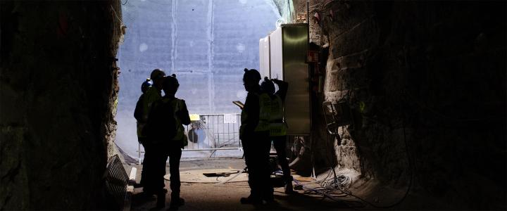 Members of the media examine the concrete back wall of a demonstration tunnel at Onkalo. They are standing in a disposal tunnel ~430 meters underground. Photo by Kate Thompson