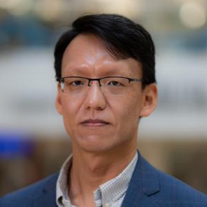Person in a blue suit jacket and short black hair